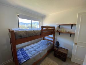 a bedroom with two bunk beds and a window at Departamento Papudo Condominio Punta Fundadores in Papudo