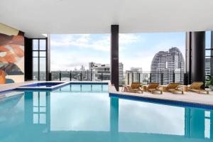 una piscina con sillas y vistas a la ciudad en Nearly New Level 38 Broadbeach Casino 1 BDR Unit, en Gold Coast