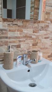 a bathroom sink with two baskets on top of it at Guest rooms KRASI 