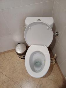 a white toilet in a bathroom with a trash can at Guest House Lili in Petrich