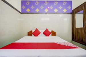 OYO Green Park في فيلوري: غرفة نوم مع سرير أبيض كبير مع وسائد حمراء
