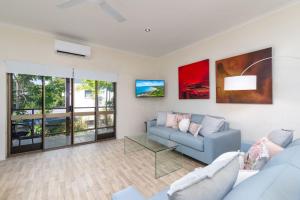 ein Wohnzimmer mit einem Sofa und einem Tisch in der Unterkunft Villa 5 Marlin Terraces in Port Douglas