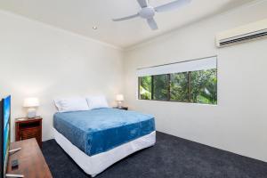 1 dormitorio con cama y ventana en Villa 5 Marlin Terraces, en Port Douglas