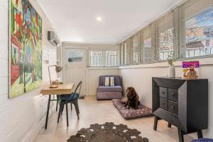 a living room with a dog sitting on a dog bed at Golden Square Gold Class Guest House, Bendigo in Golden Square