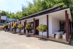 ein Gebäude mit Topfpflanzen nebeneinander in der Unterkunft Bwalk Hotel Malang in Sengkaling