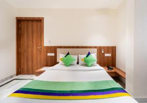 a bedroom with a bed with a rainbow bedspread at Treebo Kaveri in Nashik +30 photos