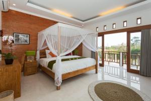 a bedroom with a canopy bed and a balcony at Villa Sari Tagtag Bali in Sanur +52 photos