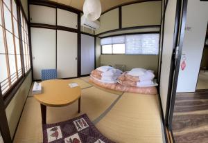 2 camas en una habitación con mesa en 松本はなれ, en Matsumoto