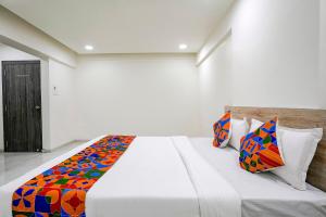 A bed or beds in a room at FabHotel Bhakti Inn
