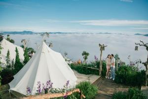 a group of people standing next to a white teepee at Cloud9 Glamping & Cafe in Xuân Trường