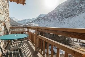 a balcony with a table and a view of a mountain at Chalet Le Bois Joli in Bonneval-sur-Arc