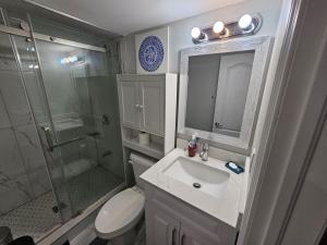 La salle de bains est pourvue d'un lavabo, d'une douche et de toilettes. dans l'établissement Exclusive 2 BR Furnished Apartment in Milton Ontario Canada, à Milton