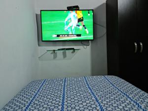 a tv on a wall in a bedroom with a bed at NEW COZY APARTMENT 101 IN MEDELLIN, ENVIGADO in Envigado