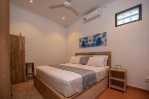 a bedroom with a bed and a ceiling fan at Asri BALI SANUR Premier Suites in Sanur