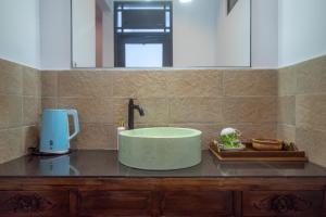 y baño con una bañera verde sobre una barra. en Asri BALI SANUR Premier Suites, en Sanur