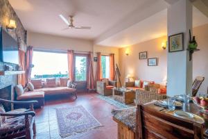 - un salon avec un canapé et une table dans l'établissement StayVista at Under The Pines, à Shimla