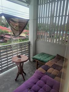 Balcón con cama, mesa y ventana en Peaceful Boutique Hotel, en Srithanu