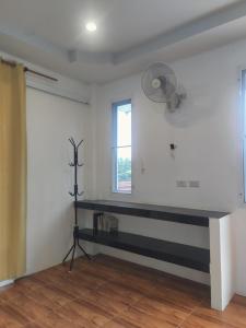 a room with a table and a fan on the wall at Peaceful Boutique Hotel in Srithanu