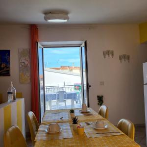 una sala da pranzo con tavolo e una grande finestra di B&B Dimora del centro a Scalea