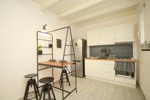 een keuken met witte kasten en een tafel en stoelen bij Casuzza bedda in Casteldaccia