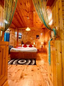 a bedroom with a bed in a wooden room at Shree Ram Cottage, Manali ! 1,2,3 Bedroom Luxury Cottages Available in Manāli