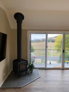 a living room with a wood stove and a sliding glass door at The Yarra Valley Couple Escape in Yarra Glen