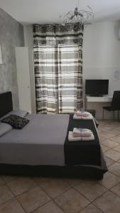 スカレアにあるB&B Dimora del centroのベッドルーム1室(ベッド2台、デスク、窓付)