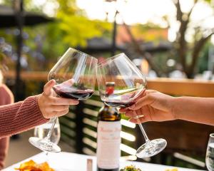 two people holding up glasses of red wine at Romantic Coastal Private Room in Oxnard