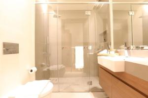 a bathroom with a shower and two sinks and a toilet at Manzil - Sleek 2BR nr Downtown & Dubai Mall in Dubai