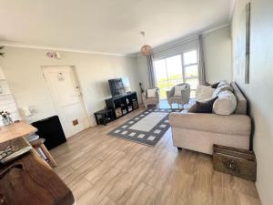 a living room with a couch and chairs in it at Bella Casa - Seaview-Beach Club Apartment in Cape Town +33 photos