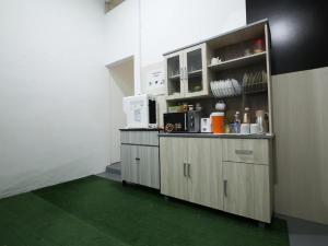 a room with a kitchen with green floors and a counter at Amida Point in Kuching