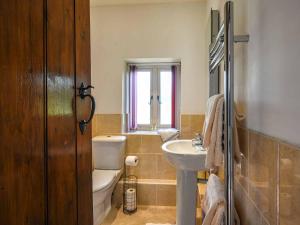 a bathroom with a white toilet and a sink at The Old Barn in Hope Bowdler