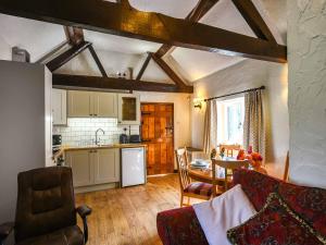 a kitchen and a living room with a couch and a table at The Old Barn in Hope Bowdler