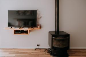 chimenea con TV de pantalla plana en la pared en Eagle View Escape en Rydal