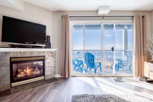 a living room with a fireplace and a view of the ocean at Waters Edge 309 in Lincoln City
