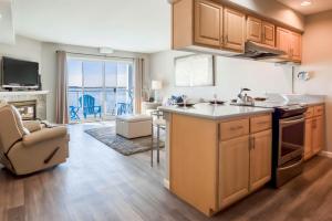 a kitchen with wooden cabinets and a living room at Waters Edge 309 in Lincoln City