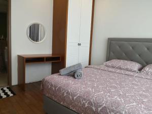 a bedroom with a bed and a table and a mirror at Vortex Suites KLCC by Sayang in Kuala Lumpur