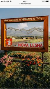 un panneau pour l'agence nova lees avec une photo des montagnes dans l'établissement Housing HELLA, à Nová Lesná
