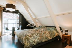 um quarto com uma cama e uma grande janela em Texels Goud Deluxe Suites em Den Burg