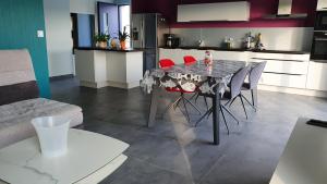 a kitchen with a table and chairs in a room at Maison récente 4* proche plage avec SPA privatif in Longeville-sur-Mer