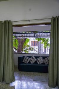 ein blaues Sofa in einem Zimmer mit Fenster in der Unterkunft Tourist Friendly Home -3BHK AC Near Birla Mandir, Hyderabad in Hyderabad