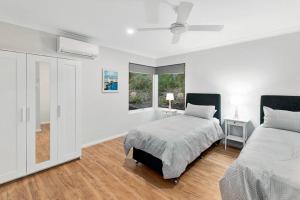 a white bedroom with two beds and a window at Evelyn @ Cape Villas, Dunsborough in Dunsborough