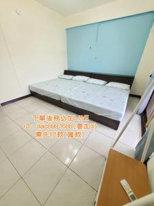 um quarto com uma cama num quarto com escrita no chão em 南科驛站 em Xinshi
