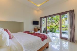 a bedroom with a bed and a large window at Green Sala Villa in Ubud