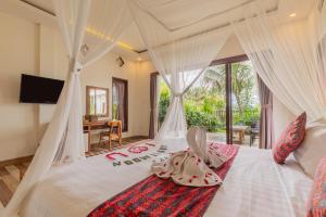 a bedroom with a white bed with a canopy at Green Sala Villa in Ubud +56 photos