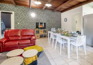 Una sala de estar con una mesa y un sofá rojo. en Le Chakouat, en Cilaos