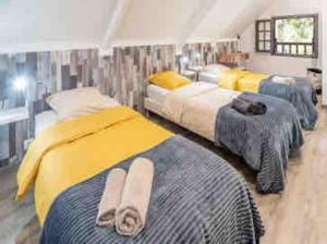 sypialnia z 3 łóżkami i ręcznikami w obiekcie Le Chakouat w mieście Cilaos