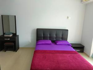 una camera da letto con un grande letto con una coperta viola di SugarStay Homestay Teluk Kemang a Port Dickson