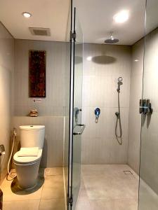 a bathroom with a toilet and a glass shower at d'primahotel Petitenget Seminyak 2 in Seminyak