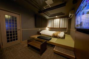 Habitación pequeña con cama y TV. en ROOM袖ヶ浦 -Adult Only-, en Sodegaura